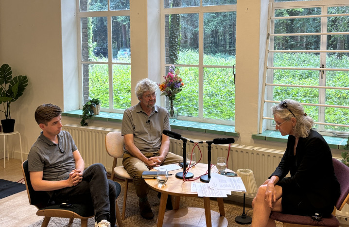 Foto van podcastopname waar de twee sprekers en interviewer in beeld zijn.