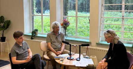 Foto van podcastopname waar de twee sprekers en interviewer in beeld zijn.